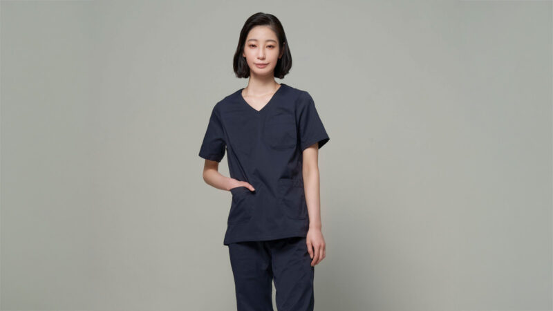 ID UNITED ARROWSのネイビーのスクラブトップスを着用した女性。